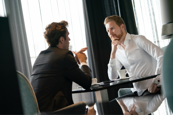 “Prospect displaying a stiff wrist gesture that signals confidence and certainty during a sales discussion.”